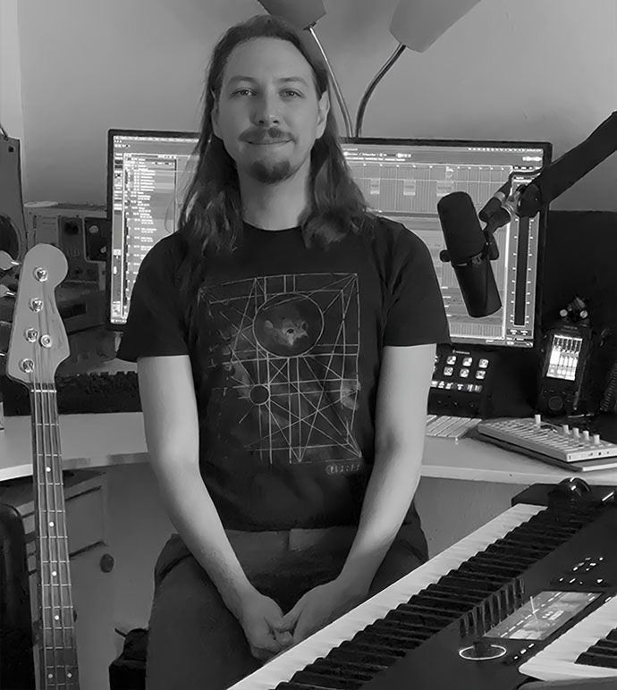 Frederik Stahlfest in his music studio with a bass guitar, keyboard, and recording equipment